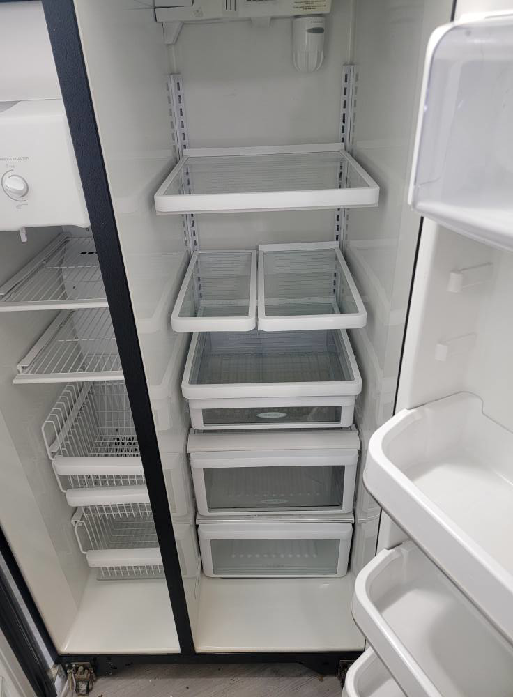 A spotless refrigerator interior with shelves and drawers after cleaning by Windham Cleaning in Akron, OH.