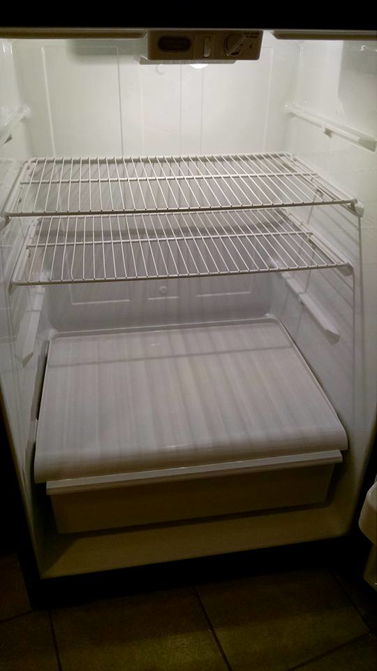 A clean and empty refrigerator interior, showcasing professional cleaning by Antioch Professional Cleaning in Manchester, NH.