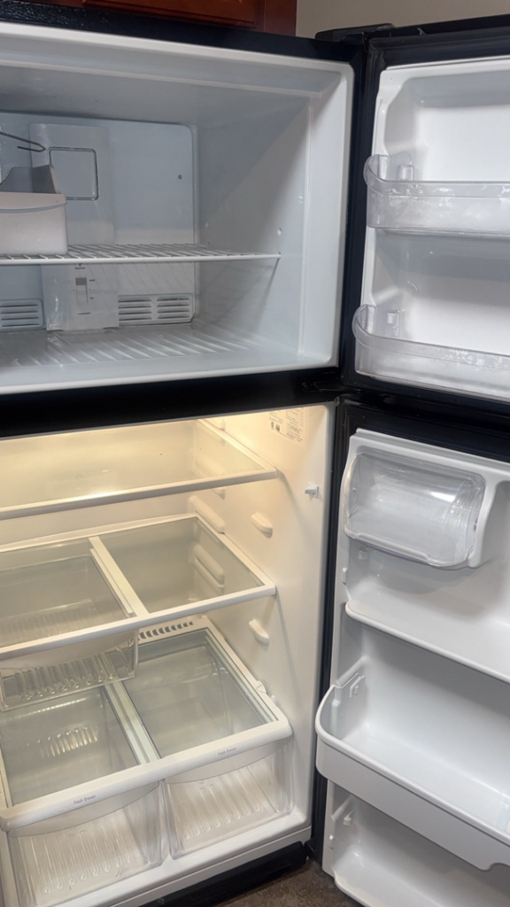 A meticulously cleaned and empty refrigerator interior, highlighting deep cleaning services by NACleaning Co. in Omaha, NE.