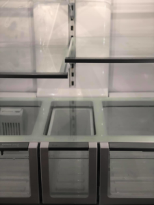 The pristine interior of a refrigerator with clean glass shelves and drawers, a service provided by Refresh Cleaning Company in Hazelwood, MO.