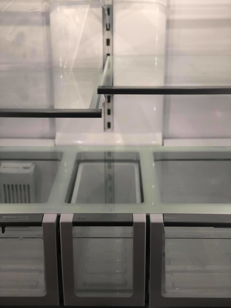 The pristine interior of a refrigerator with clean glass shelves and drawers, a service provided by Refresh Cleaning Company in Hazelwood, MO.
