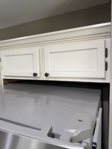 A sparkling clean refrigerator top and kitchen cabinets, showcasing the detailed cleaning by Lupita's cleaning services in San Antonio, TX.