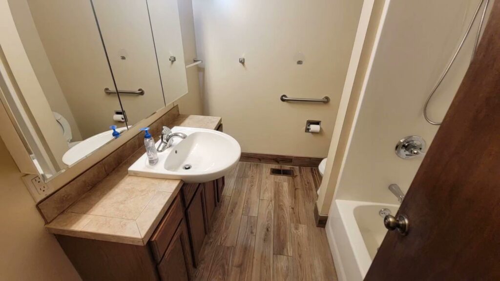 A spotless residential bathroom with a clean vanity, sink, mirror, and shower, professionally cleaned by Eyedeal Cleaning Services in Gresham, OR.