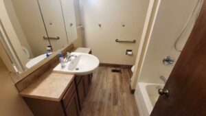 A spotless residential bathroom with a clean vanity, sink, mirror, and shower, professionally cleaned by Eyedeal Cleaning Services in Gresham, OR.