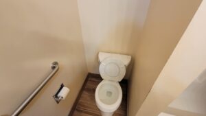 A thoroughly cleaned residential toilet in a small bathroom, showcasing the detail-oriented service of Eyedeal Cleaning Services in Gresham, OR.