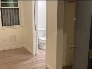 A freshly cleaned room with light wood flooring and a toilet visible in the adjacent bathroom, cleaned by Merriweather Cleaning and Laundry in Vancouver, WA.