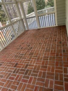 A sparkling clean red brick pattern floor on a screened porch by Just Right Cleaning Inc in Newport News, VA