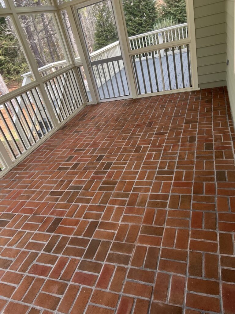 A sparkling clean red brick pattern floor on a screened porch by Just Right Cleaning Inc in Newport News, VA