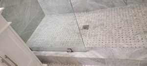 A sparkling clean shower floor with mosaic tiles, showcasing the excellent results of bathroom cleaning by Jolley Services, INC in Bossier City, LA.