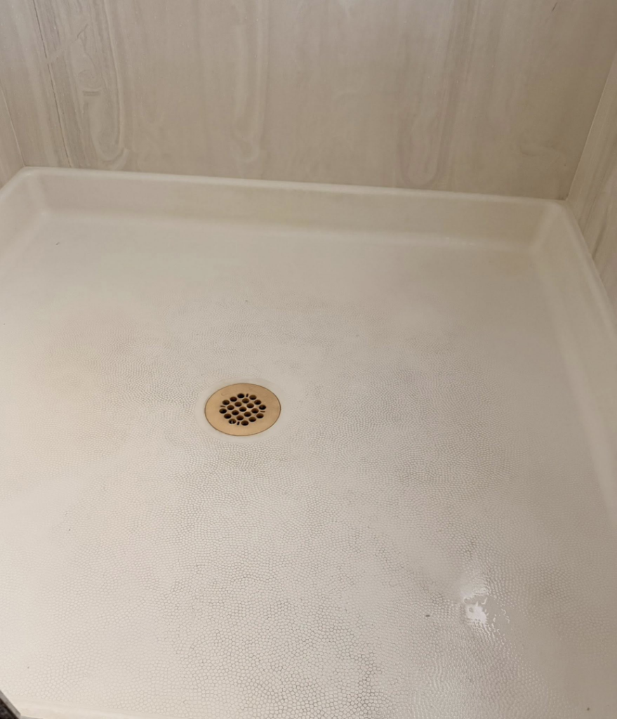 A sparkling clean shower pan after professional cleaning by Lindi's Clean Living, LLC in Tucson, AZ.