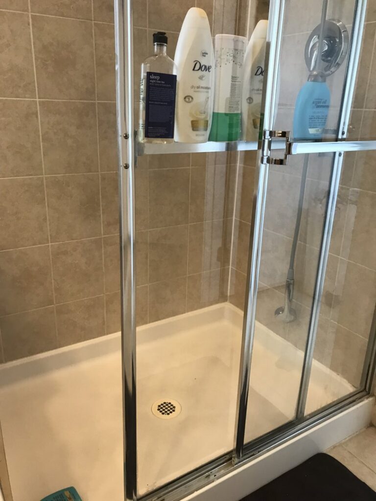 A clean shower stall with neatly arranged toiletries, sparkling after service from West & Co Cleaning Services in Laurel, MD