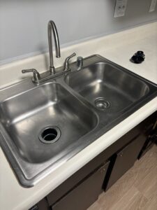 A gleaming stainless steel double sink in a kitchen, thoroughly cleaned by Bee Clean Solutions in Lexington, KY.