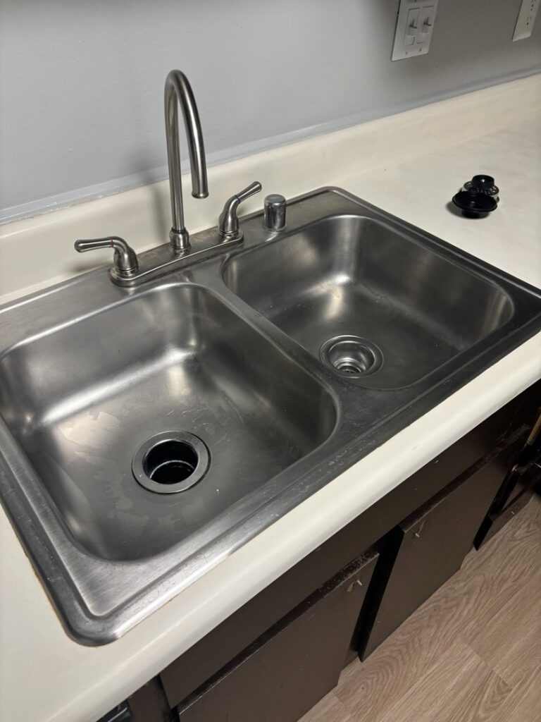 A gleaming stainless steel double sink in a kitchen, thoroughly cleaned by Bee Clean Solutions in Lexington, KY.