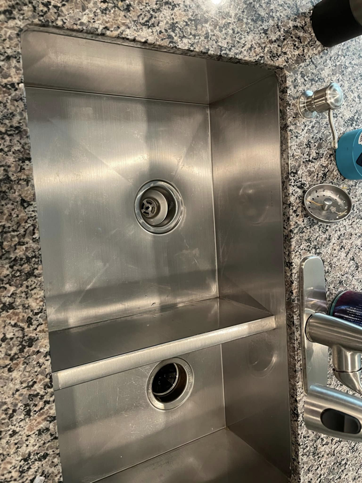 A gleaming clean stainless steel kitchen sink with granite countertops, cleaned by Maid It Dirty Cleaning Company in Phoenix, AZ.
