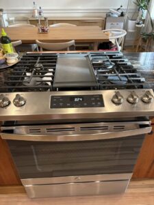 A sparkling clean stainless steel stove and oven in a modern kitchen, showcasing professional cleaning by New Image Cleaning Service LLC in Richmond, VA.