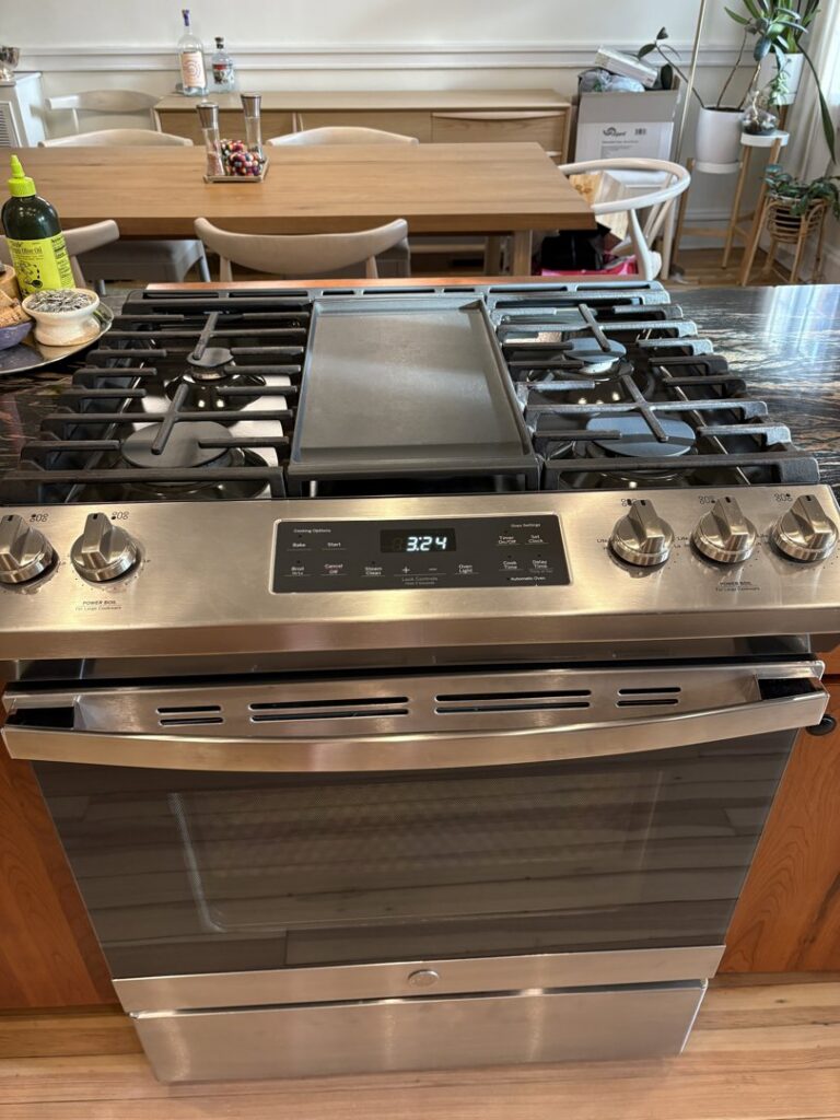 A sparkling clean stainless steel stove and oven in a modern kitchen, showcasing professional cleaning by New Image Cleaning Service LLC in Richmond, VA.