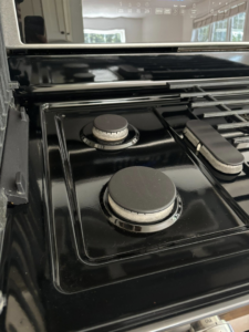 A shiny, clean stovetop with burners after professional cleaning by Tidy Townhouses in Manchester, NH.