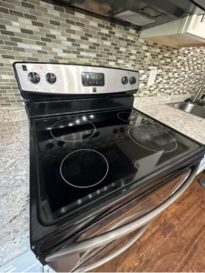A close-up of a clean stovetop and kitchen backsplash, reflecting detailed cleaning by Magic House Cleaning in Fayetteville, NC.