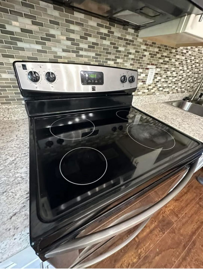 A close-up of a clean stovetop and kitchen backsplash, reflecting detailed cleaning by Magic House Cleaning in Fayetteville, NC.