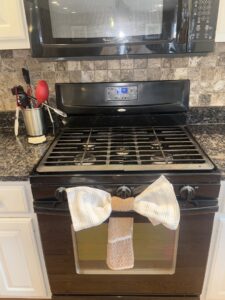 A sparkling clean stovetop with a decorative towel, showcasing the meticulous cleaning by Messy To Clean in Aurora, IL.