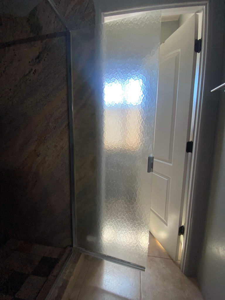 A clean textured glass shower door, professionally cleaned by Lindi's Clean Living, LLC in Tucson, AZ.