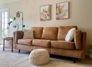 A clean and tidy living room with a brown sofa and rug, maintained by Lindi's Clean Living, LLC in Tucson, AZ.