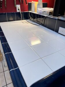 A spotless tiled kitchen counter with dark blue trim, cleaned by Sage & Soap Cleaning Co in Kansas City, MO.