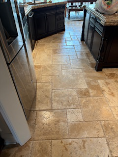 A sparkling clean tiled kitchen floor with dark wood islands and stainless steel appliances by Integrity Cleaning Solutions in Loves Park, IL