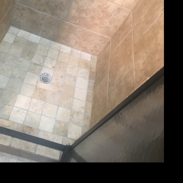 A sparkling clean tiled shower floor, demonstrating bathroom cleaning services by Magic Maids in Bremen, AL.