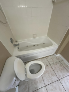 A clean toilet and jetted bathtub in a well-maintained bathroom, showcasing services from CLEAN That SHEET LLC in Jacksonville, FL.