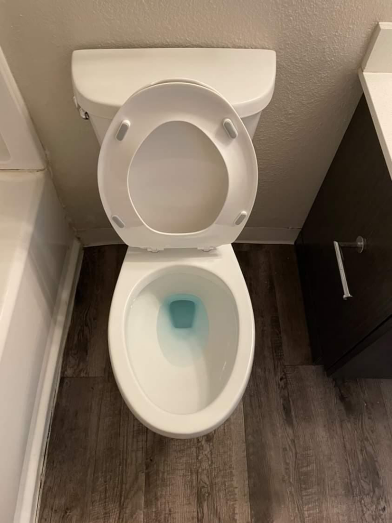 A sparkling clean toilet with blue cleaning solution, showcasing the quality work of Five-S Cleaning Plus in Phoenix, AZ