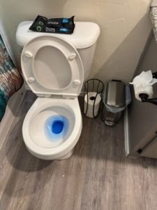 A sparkling clean toilet with blue cleaning solution in the bowl, cleaned by Okie Clean Bee in Tulsa, OK
