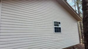 Clean light-colored vinyl siding on a house after professional washing by Plains Power Washing in Auburn, AL.