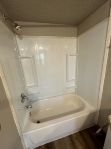 A sparkling clean white bathtub and shower after professional cleaning by Dust Devil Cleaning in Eugene, OR.