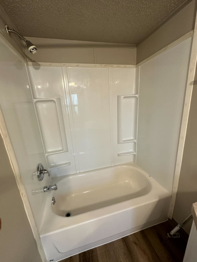A sparkling clean white bathtub and shower after professional cleaning by Dust Devil Cleaning in Eugene, OR.
