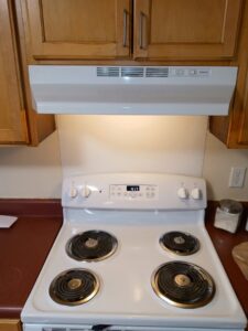 A sparkling clean white stove and range hood, cleaned by Whole New World Cleaning Service, LLC in Wilmington, DE