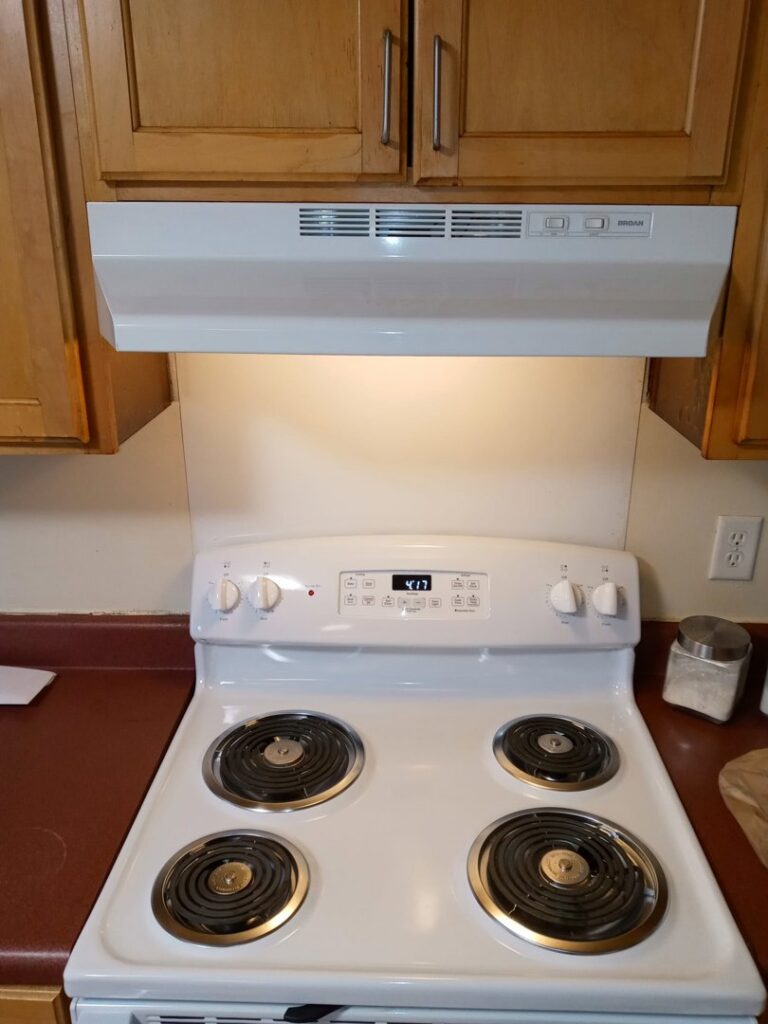 A sparkling clean white stove and range hood, cleaned by Whole New World Cleaning Service, LLC in Wilmington, DE