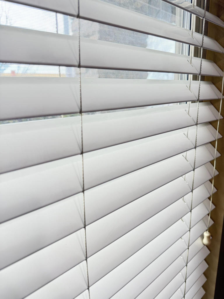 Sparkling clean window blinds in a home, showcasing the results of Caro's Pro Cleaning Services in Orem, UT.