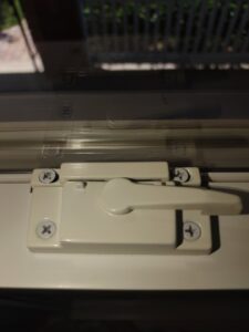 A clean white window latch, demonstrating attention to detail in house cleaning by Maid to Serve HIM in Cincinnati, OH.
