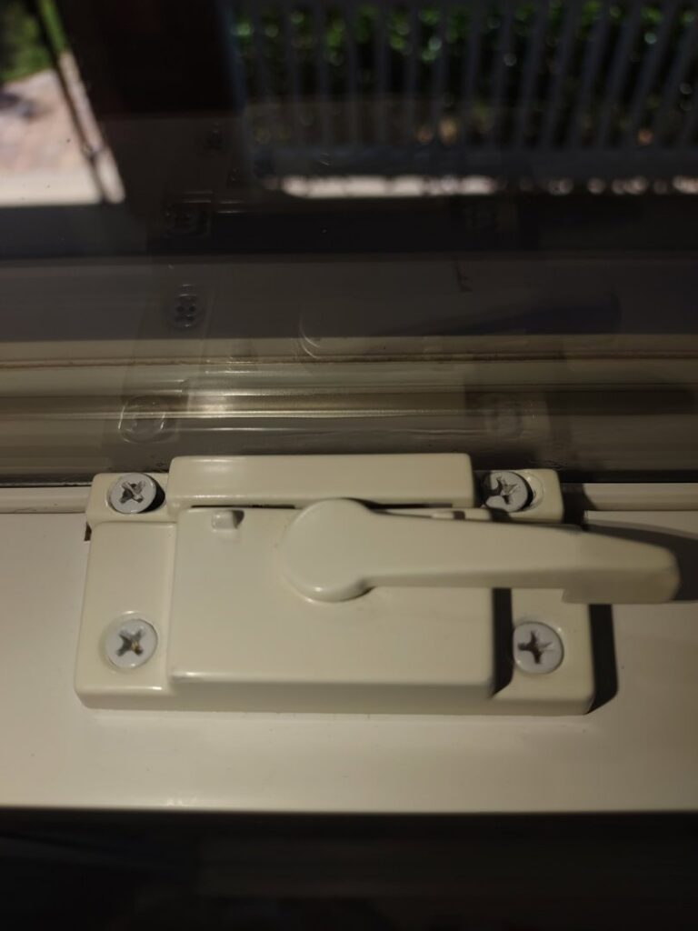 A clean white window latch, demonstrating attention to detail in house cleaning by Maid to Serve HIM in Cincinnati, OH.