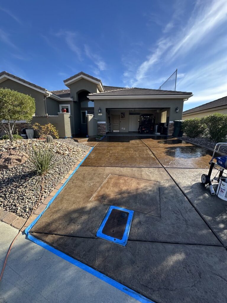 A freshly cleaned residential driveway with protective blue tape by Farki Pressure Washer LLC in Mesquite, NV
