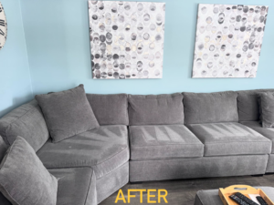 A freshly cleaned gray sectional sofa with vacuum lines by J&J clean services in Pittsburgh, PA.