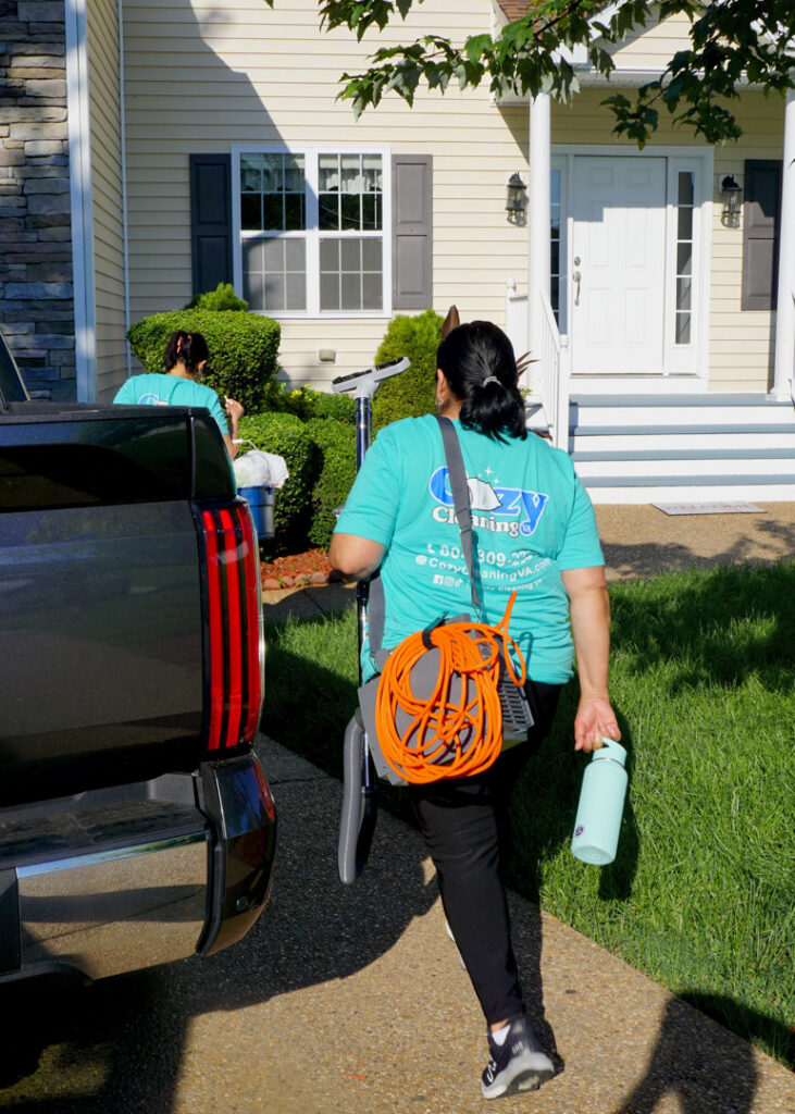 A professional cleaner from Cozy Cleaning VA arriving at a client's home with cleaning equipment in Richmond, VA.