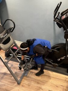 A cleaner from Fabylous Cleaning Service cleaning exercise equipment in a home gym in Anaheim, CA.