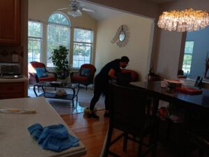 A cleaner from Bivian's Cleaners LLC cleaning the floor in a living room area in Trenton, NJ.