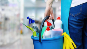 A house cleaner holding a blue bucket filled with various cleaning supplies for Milwaukee Cleaning Services in Milwaukee, WI.