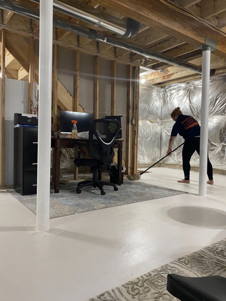 A cleaner from Bivian's Cleaners LLC mopping a freshly cleaned basement floor in Trenton, NJ.