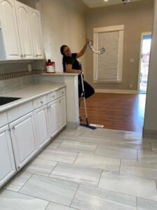 A house cleaner from Denver MOP STARS Cleaning Service mopping a kitchen floor in Denver, CO.