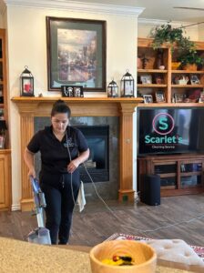 A professional cleaner mopping the living room floor, demonstrating house cleaning services by Scarlet Cleaning Service LLC in Bronx, NY.