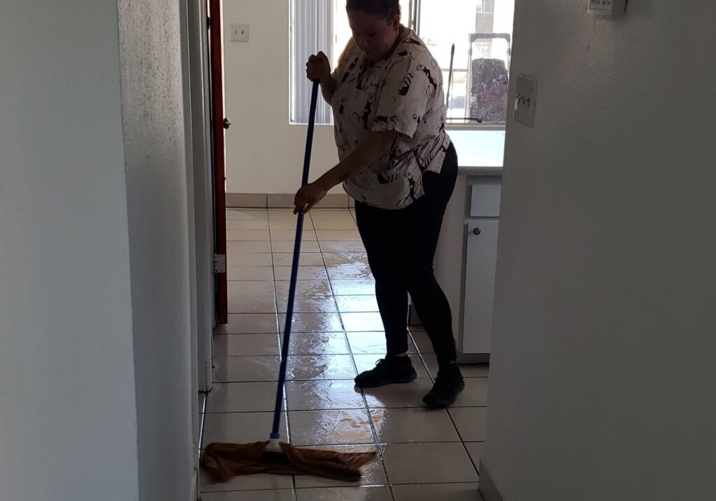 A cleaner mopping a tiled floor in a home, demonstrating services by Marymen Cleaning Services in Las Vegas, NV.